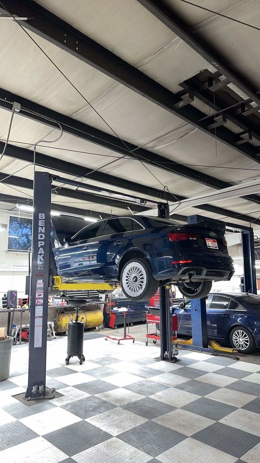 Vehicle on the lift inside the High Desert Auto & Repair shop
